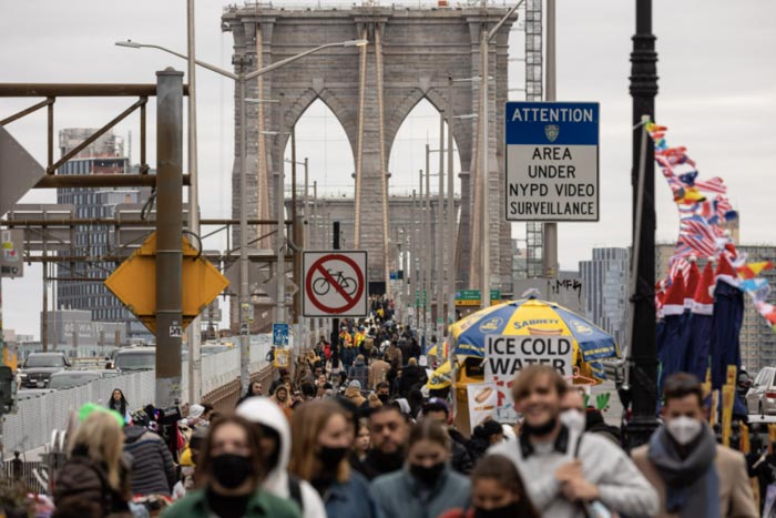 Tourists walk through the Brooklyn Bridge in New York City.