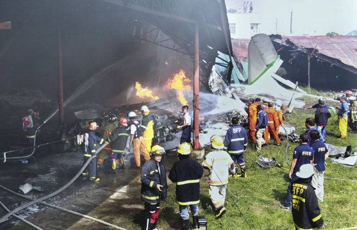 Firefighters try to extinguish a fire after a plane crash into a neighborhood warehouse Saturday, October 17, 2009 in suburban Las Pinas south of Manila, Philippines. A propeller-driven plane on a test flight has crashed and burst into flames near a crowded neighborhood in a Manila suburb. (AP Photo)