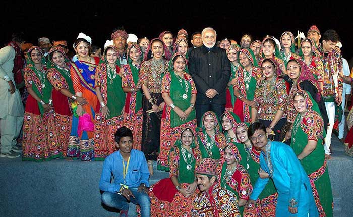 Prime Minister with a cultural troupe during 3-day DGP Conference at Dhordo, Kutch. (PTI Photo)