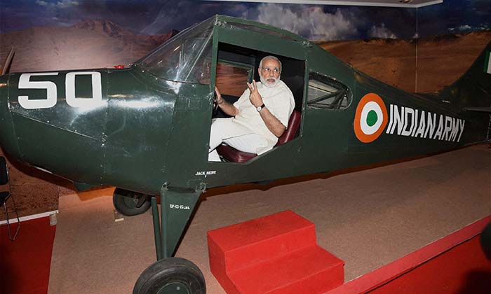 PM Modi poses with a small plane at the exhibition on the Golden Jubilee of the 1965 Indo-Pak War.