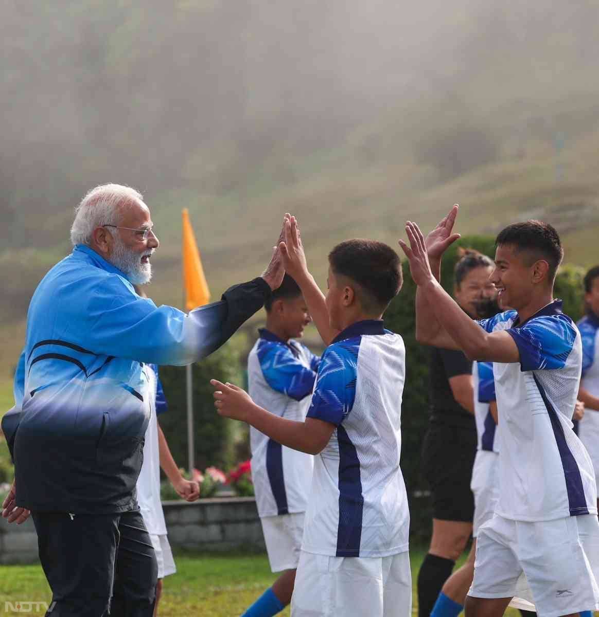 पीएम मोदी ने सोशल मीडिया पर कुछ तस्वीरें साझा कीं जिनमें वह लड़के-लड़कियों के साथ फुटबॉल खेलते नजर आ रहे हैं.