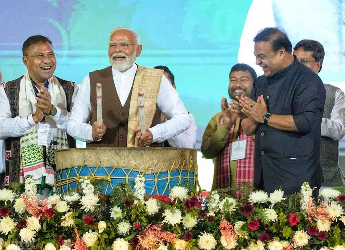 PM Modi आसाम के Sarusajai Stadium में एक कार्यक्रम के दौरान ड्रम बजाते हुए.