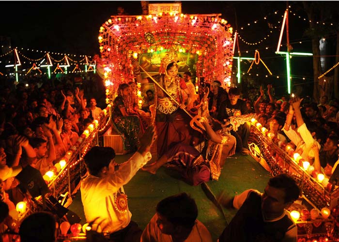 A woman dressed as Goddess Durga, reenacts myths during Durga Puja in Allahabad on September 24, 2009. Durga Puja is all about wearing new clothes and going from one pandal to another with friends and family. Durga, in Sanskrit means, 'She who is incomprehensible or difficult to reach.' Mother of the Universe, Goddess Durga represents the infinite power of the universe and is a symbol of a female dynamism. (AFP Photo)