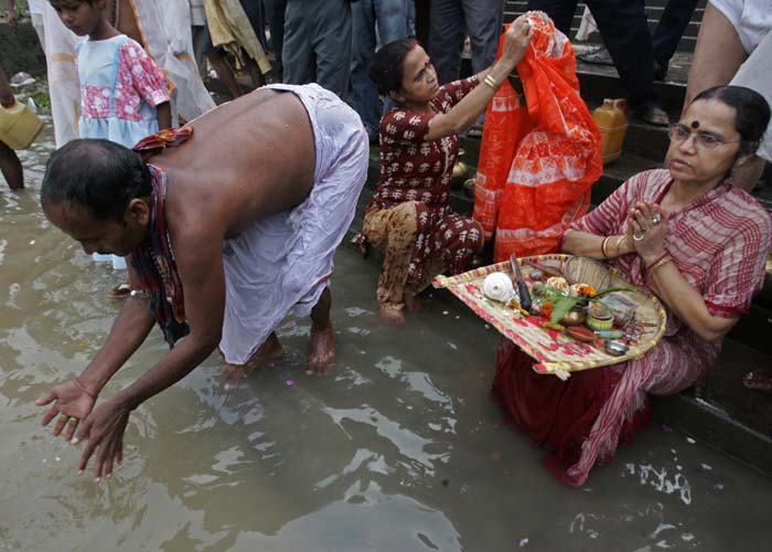 Devotees perform rituals on the banks of river Ganga in Calcutta on Friday, September 25, 2009. The five festive days of Durga Puja are celebrated with aplomb. Rituals are accompanied with <em>dhak</em> (playing ceremonial drums), <em>dhunuchi</em> dance (a way of offering prayer), <em>shiuli</em> (small scented flowers with cream petals and orange pedicle) and <em>kaash</em> (flowers looking like the willows, that cover the horizon with a milky white appearance). (AP Photo)