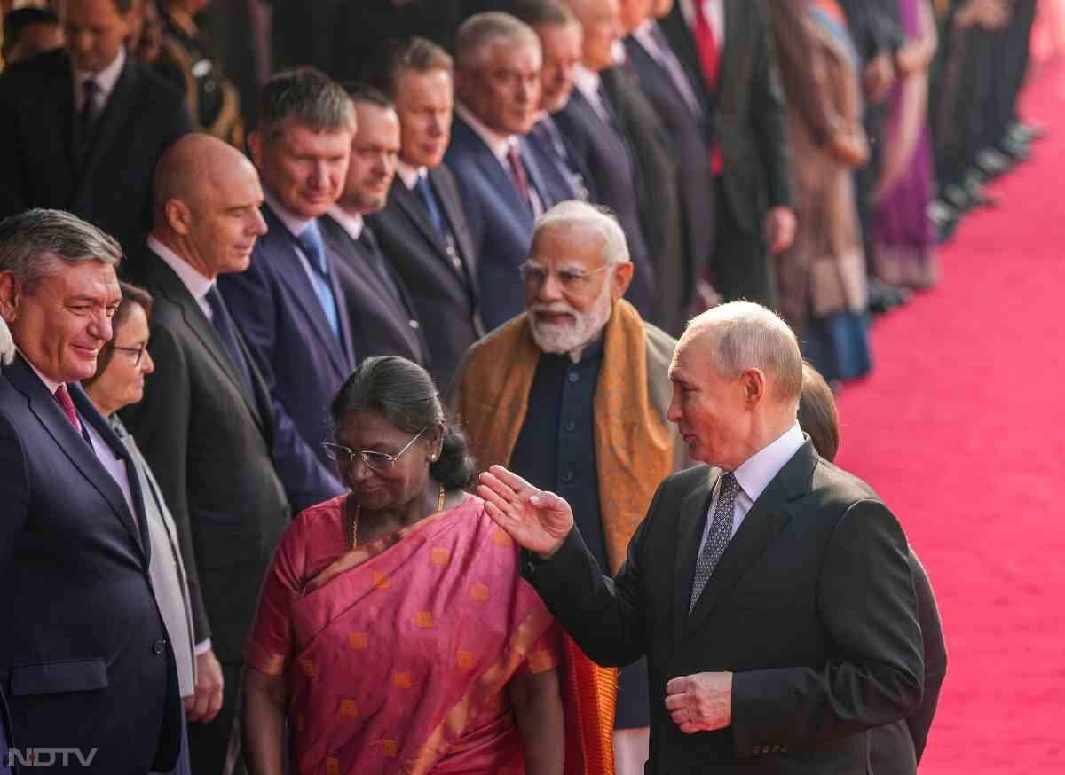 अपनी टीम से मिलाते पुतिन.