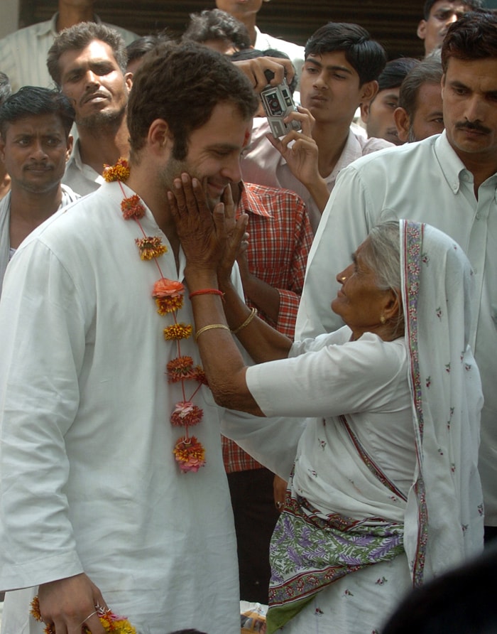 Rahul was once again at his mother's side when she announced her resignation from the Lok Sabha and also as chairperson of the National Advisory Council on March 23, 2006, under the office-of-profit controversy. Sonia then vowed to seek a fresh mandate in Rae Bareli, which sent her to power in 2004. She was re-elected in May 2006 by a huge margin of over 400,000 votes. In this May 6, 2006 file photo Rahul is embraced by an elderly woman as he walks among supporters in Rae Bareli District, during electoral campaigning for the by-elections. (Photo: AFP)