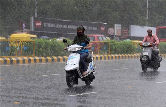 Seen here, motorcyclists caught unaware get drenched in the rains in Ahmedabad.