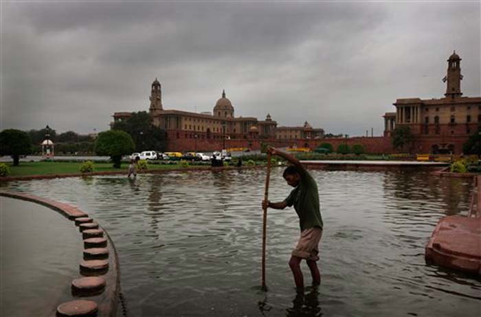 It was a cloudy, pleasant morning in the national capital. The city received light showers in the morning. Seen here, Delhi municipal workers clean water from a fountain at Raisina hills as monsoon clouds are hanging over the sky in New Delhi.