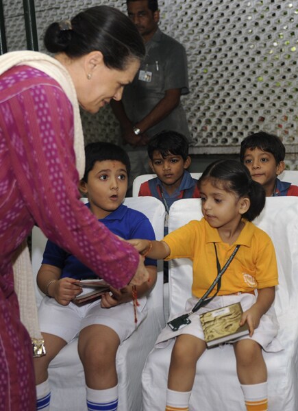 UPA chairperson Sonia Gandhi also celebrated the festival at her residence with school children. In this picture, she ties a Rakhi to children at her residence. (AFP Photo)