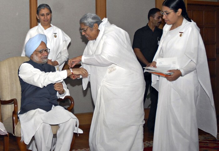 A nun ties a Rakhi to Indian Prime Minister Manmohan Singh during a ceremony at his residence. (AFP Photo)