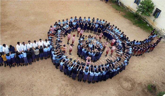 School kids make a human chain in the shape of a 'Rakhi' on the occasion of Raksha Bandhan festival in Chikmagalur on Tuesday. (PTI Photo)