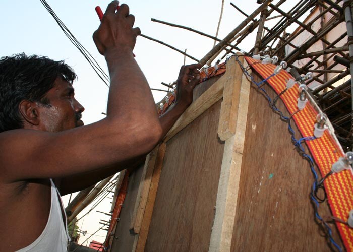 <strong>Let there be light:</strong> This man sweats it out in the particularly hot September sun. He knows on him lies the onus of illumination. (NDTV Photo)