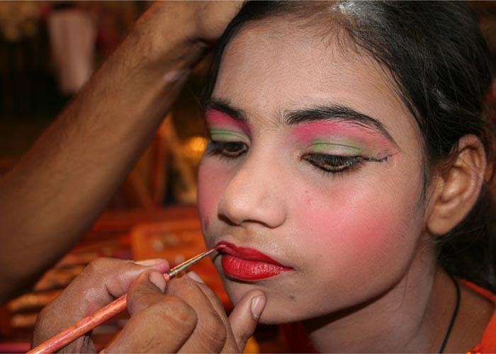 <strong>Rainbow:</strong> Up close the colours he is painting on her face look stark, garish even. From a great distance, the red will define the lip as she mouths her dialogue. (NDTV Photo)