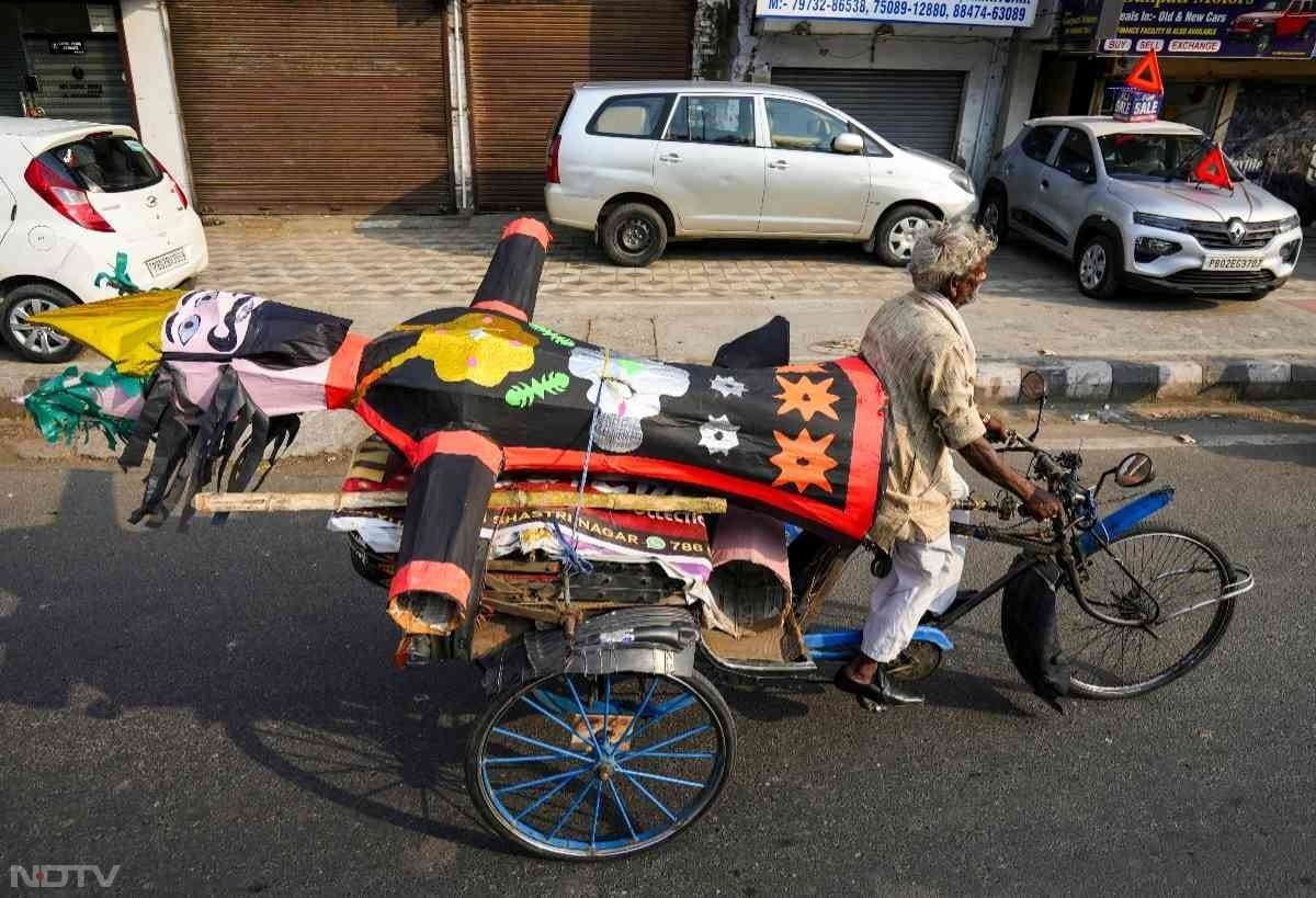 दशहर उत्सव के लिए रावण के पुतले को उसके ठिकाने पर पहुंचाते हुए शख्स. दशहरे को लेकर लोगों में काफी उत्साह है.