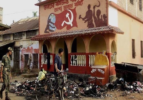<b>Destruction leaves a trail:</b> A paramilitary soldier patrols past the office of the Communist Party of India-Marxist(CPM), vandalized by activists of 

People's Committee Against Police Atrocities (PCPA) at Lalgarh. (AP)