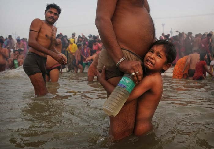 In this January 14 photo, a child reacts after being taken for a dip at Sangam.