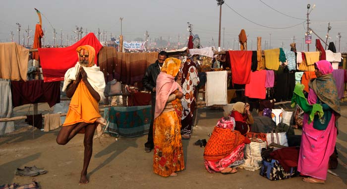 In this February 11 photo, a man is seen prays standing on one leg as other dry their cloths after a holy dip at Sangam.