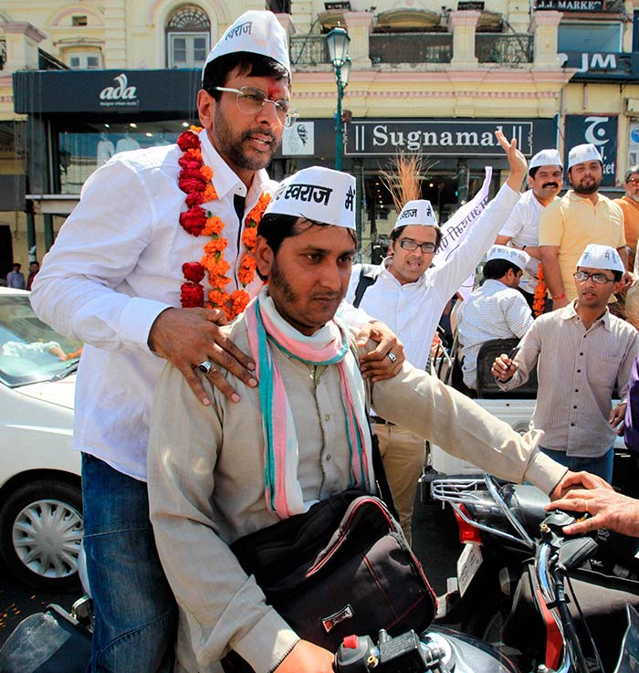 Bollywood actor and AAP party candidate Javed Jafferi campaigns on a motor cycle during an election rally in Lucknow.