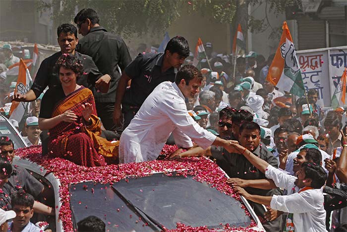 Vice President of India's ruling Congress party Rahul Gandhi shakes hand with supporters, as he travels to file his nomination for the ongoing general elections in Amethi, in Uttar Pradesh. He and sister Priyanka Vadra sit on top of an open roofed SUV.