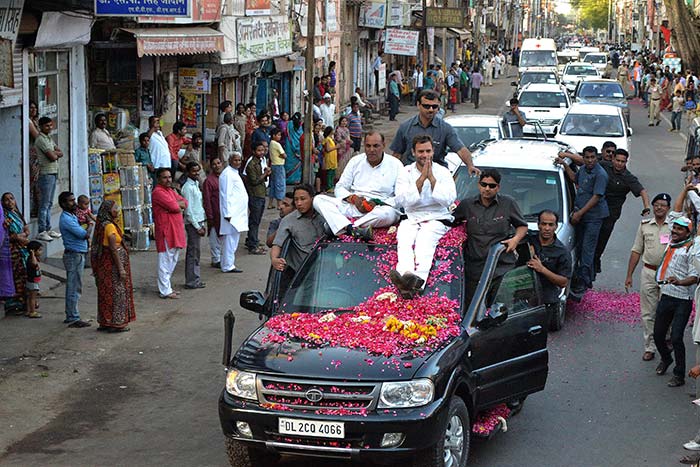 Congress party Vice President Rahul Gandhi sits on the roof of a black Tata Safari during an election rally in Gwalior.