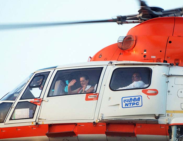 Congress President Sonia Gandhi waves as she flies off in a helicopter.