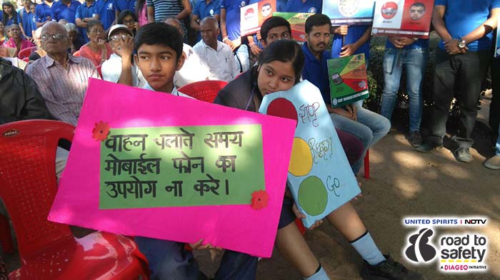 Seen here are two students sitting with message boards to promote road safety.