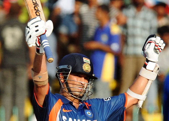 Sachin Tendulkar raises his bat in the air to celebrate his century during the Compaq Cup tri-series final match against Sri Lanka in Colombo. (AFP Photo)