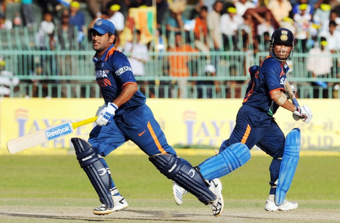 Mahendra Singh Dhoni and teammate Sachin Tendulkar run between wickets during the Compaq Cup tri-series final match against Sri Lanka in Colombo. (AFP Photo)