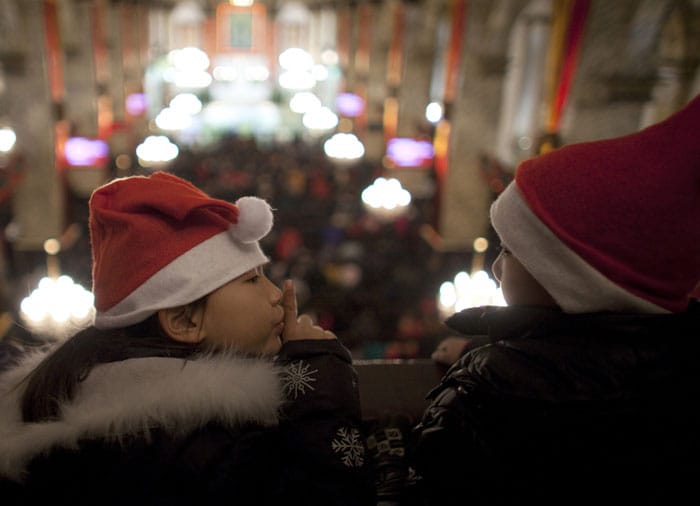 A girl gestures to ask a boy to keep silent during a Christmas Eve Mass at the official Catholic church South Cathedral in Beijing, China, Friday, Dec. 24, 2010. (Photo courtesy: AP)