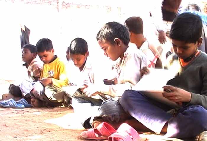 <b>Tentative shadows</b><br><br>Children study in the open at the school.