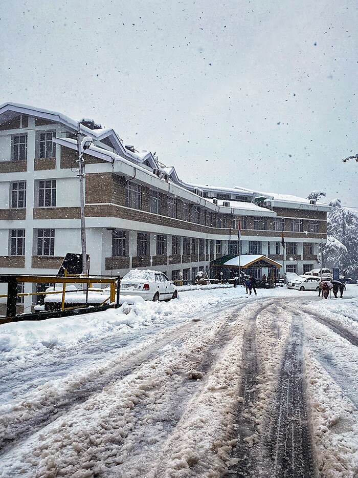 People walking on the snow-covered road amid fresh snowfall, in Shimla on Saturday. (ANI Photo)