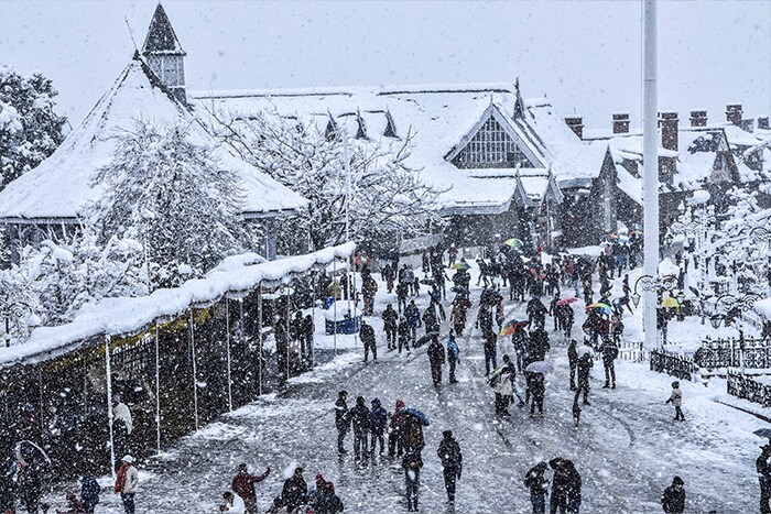 Tourists at the snow-covered Ridge during heavy snowfall in Shimla, Sunday, Jan. 23, 2022.