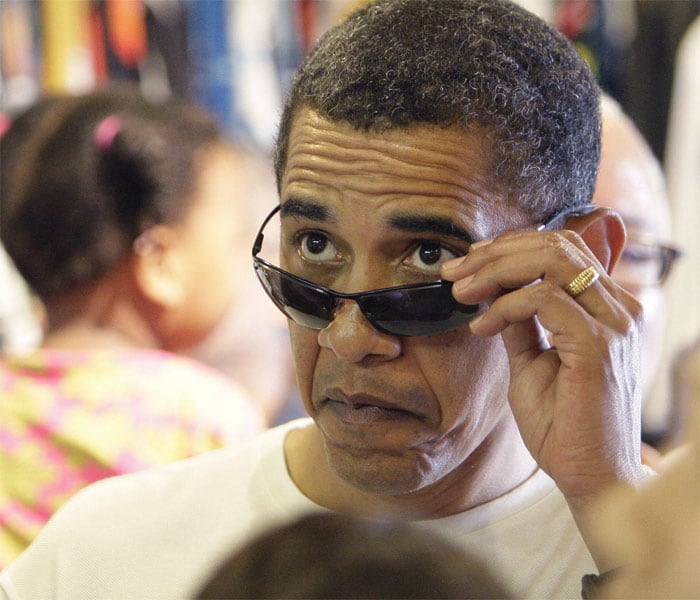 US President Barack Obama looks over his sunglasses at the menu of shave ice at Island Snow, in Hawaii. The Obamas are in Hawaii for the holidays. (AP Image)