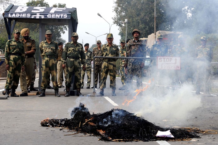 Protests took place in Amritsar on February 22. Here, we see the Border Security Force personnel stand guard and watch a burning effigy of Pakistan-based Taliban militants during a protest by members of the Bharatiya Janata Party (BJP) at the India-Pakistan Wagah Border. (AFP Photo)