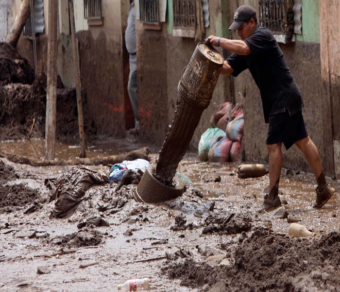 Residents were seen dumping mud removed from their houses after the Mico river overflowed due to heavy rains from Tropical Storm Agatha in Guatemala.(AP Image)