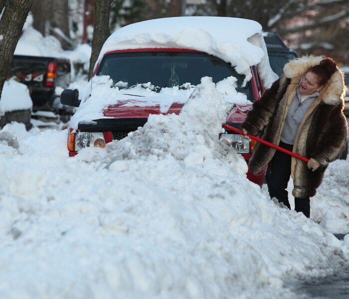 Kathy Bloom of Absecon digs her truck out of a snowbank along East Wyoming Avenue following Saturday's major snow storm in Absecon, New Jersey. (AP Photo)