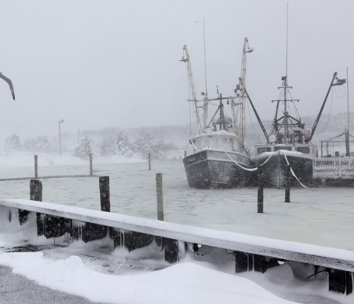 Fishing boats sit in Rock Harbor in Orleans, Mass, during the first major snowstorm of the season on Sunday, December 20, 2009. (AP Photo)