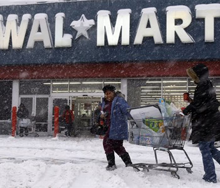 Shoppers struggle with their cart in the snow during a snow storm on Saturday in Philadelphia, US. Those who did venture out were treated to nearly desolate stores on what is usually one of the busiest shopping days of the year.(AP Photo)