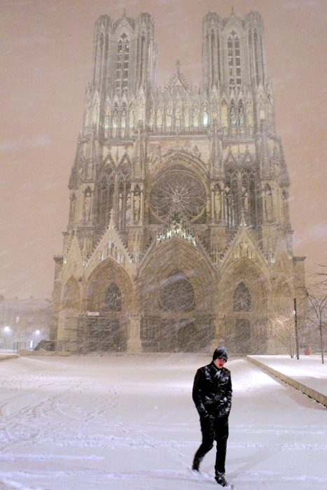 A man walks in front of the Notre-Dame de Reims cathedral as snow falls heavily on December 18, 2010 in Reims, northern France. Heavy snow disrupted European air travel Saturday and stranded hundreds of drivers in their cars as far south as Italy as a white Christmas appeared increasingly likely for many places. (AFP Photo)