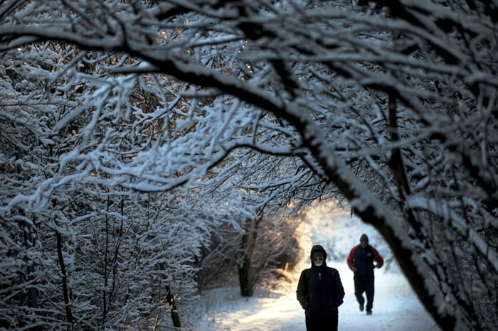 People walk in a park after a snowfall in Sofia on December 14, 2010. (AFP Photo)