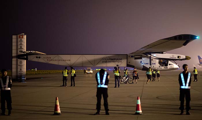 Chinese security staff members stand guard shortly before the Swiss-made solar-powered plane Solar Impluse 2 takes off from Nanjing's Lukou International Airport in Nanjing, in China's eastern Jiangsu province, early on May 31, 2015. AFP PHOTO / JOHANNES EISELE