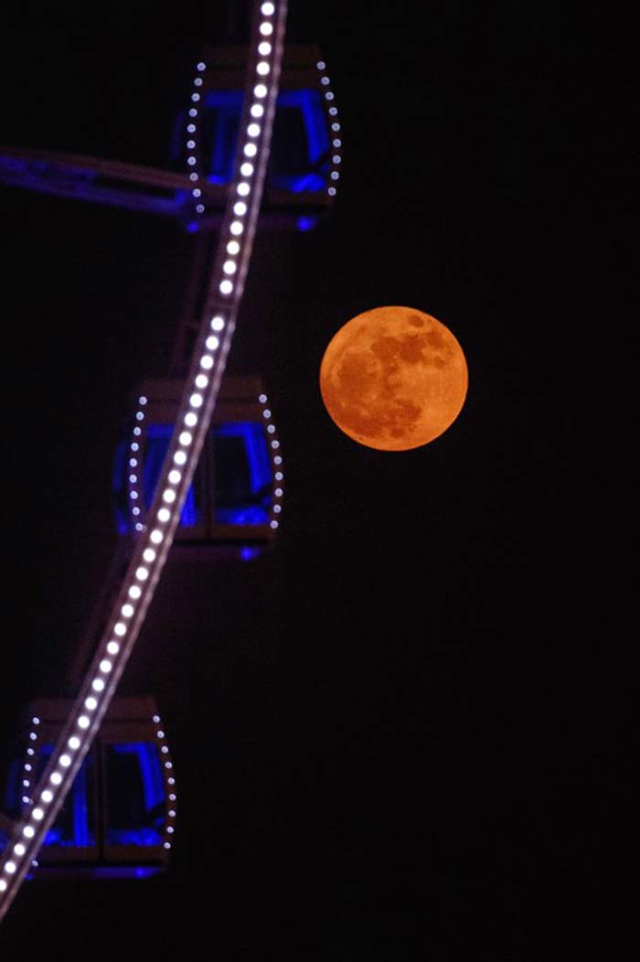 "Supermoon" is seen beyond a ferris wheel in Hong Kong. (AFP Photo)