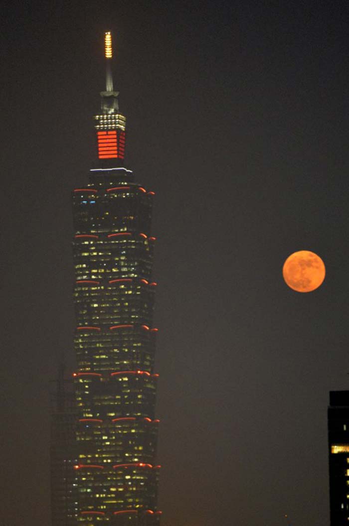 "Supermoon" rises next to the Taipei 101 building, a 508-meter high skyscraper, in Taipei. (AFP Photo)