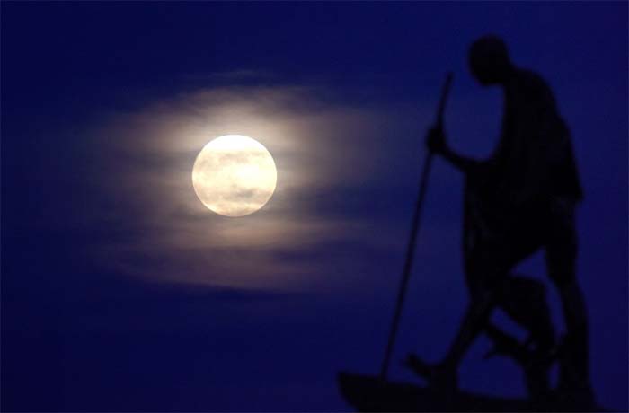 "Supermoon" rises behind the a statue of Mahatma Gandhi at Marina Beach in Chennai. (AFP Photo)