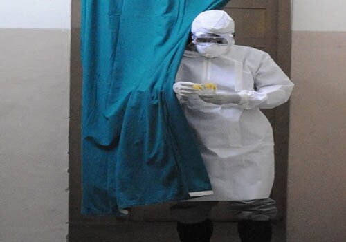 A medical technician comes out of the isolation room after collecting samples from suspected patients of H1N1 flu admitted to the Government Chest Hospital in Hyderabad. (AFP)