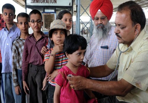 Pakistani children queue up for a medical check as Indian doctors check for symptoms of swine flu on their arrival at the international Attari Railway station, about 35 kms from Amritsar. The government sounded a high alert for swine flu at all international entry and exit points. (AFP)