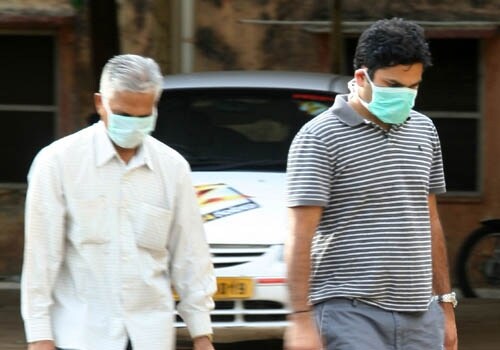 Pedestrians walk wearing masks outside the Government Chest Hospital in Hyderabad. Patients with suspected cases of swine flu, which were detected at the hospital, were quarantined and kept under observation. Their nasal and throat swabs were sent to National Institute of Communicable Diseases (NICD) in New Delhi. (AFP)