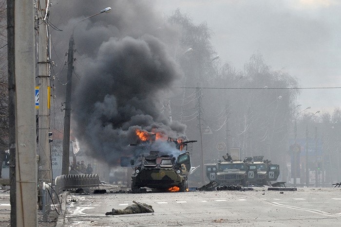 A Russian vehicle burns next to an unidentified soldier's body during street fighting with Ukrainian armed forces in the country's second largest city, Kharkiv.