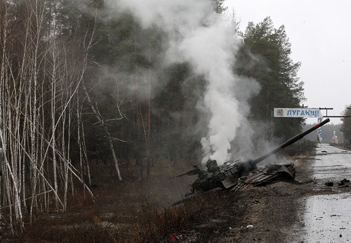 Smoke rises from a Russian tank destroyed by the Ukrainian forces on the side of a road in the separatist-controlled Lugansk region.