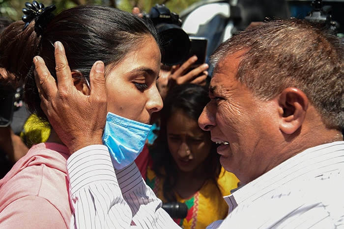 A man embraces his daughter who was evacuated from Ukraine, after her arrival in Ahmedabad.